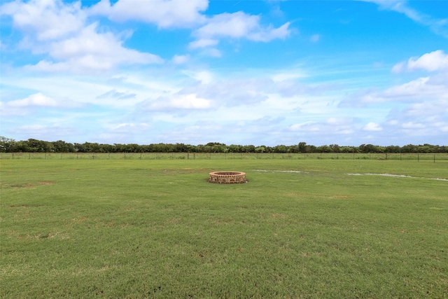 view of yard with a rural view and a fire pit