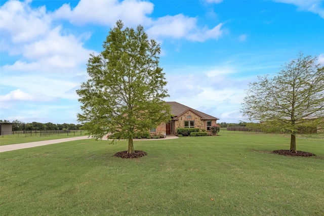 view of front facade with a front lawn, fence, and stone siding