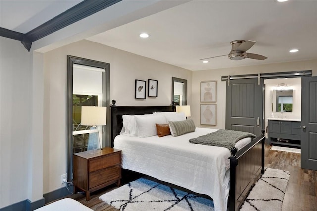 2449 Tanglewood Blvd, Pottsboro, TX 75076 - bedroom with a barn door, dark wood-style floors, recessed lighting, connected bathroom, and ceiling fan
