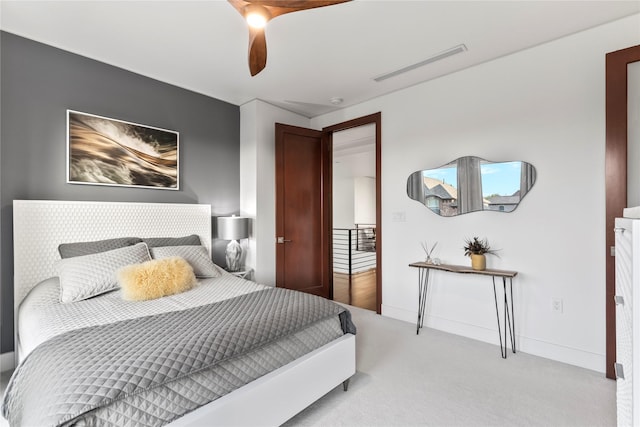 bedroom with light colored carpet, a ceiling fan, and visible vents