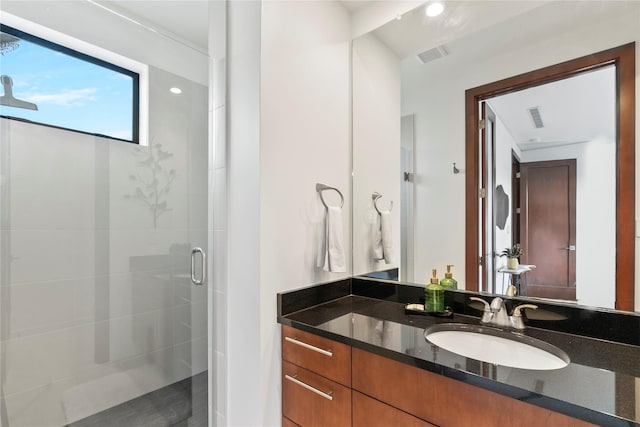 bathroom featuring visible vents, vanity, and a shower stall