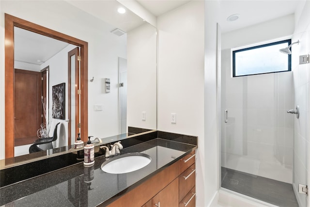 bathroom featuring vanity, a stall shower, and visible vents