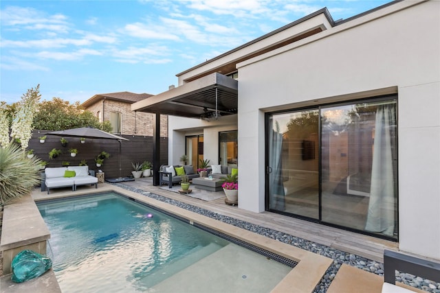 back of house featuring fence, a balcony, stucco siding, an outdoor hangout area, and a fenced in pool