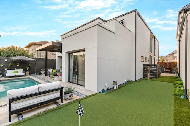 back of property with a fenced backyard, a fenced in pool, stucco siding, and a patio area