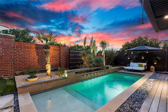 view of swimming pool with a fenced in pool, a fenced backyard, and a deck