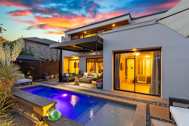 back of property with fence, a balcony, stucco siding, an outdoor hangout area, and a fenced in pool