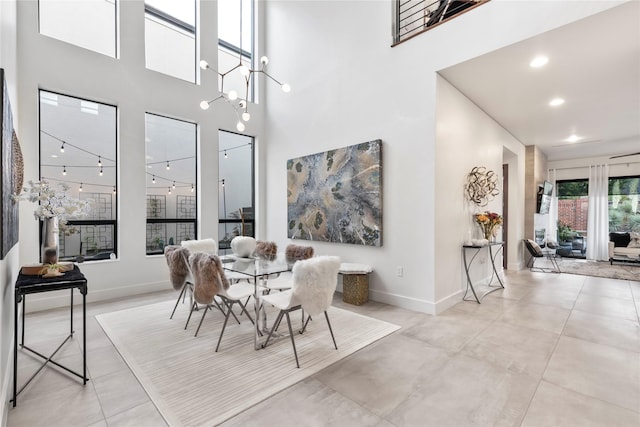 dining space with baseboards, recessed lighting, and a towering ceiling