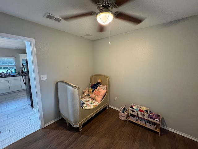 1617 Tyson St, Blue Mound, TX 76131 - bedroom with ceiling fan, a textured ceiling, visible vents, wood finished floors, and baseboards