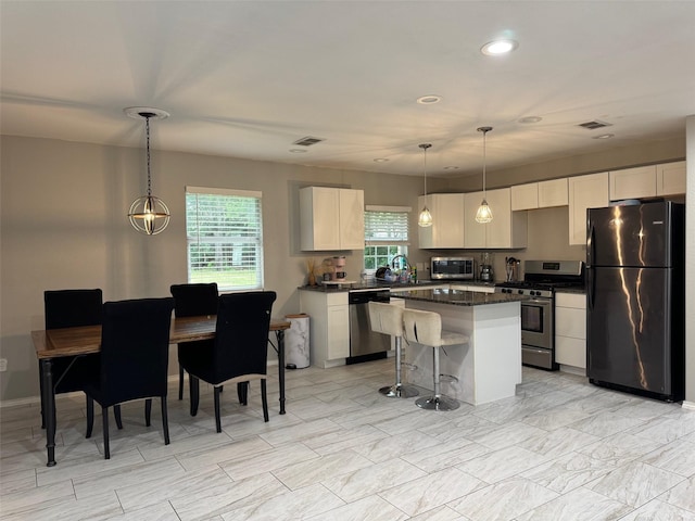 1617 Tyson St, Blue Mound, TX 76131 - kitchen featuring a center island, white cabinetry, a breakfast bar, and stainless steel appliances