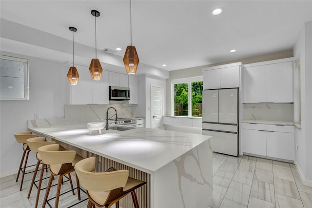 1619 Homeland St, Dallas, TX 75212 - kitchen featuring a peninsula, a kitchen breakfast bar, visible vents, backsplash, and appliances with stainless steel finishes