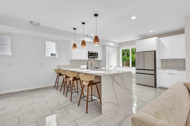 1619 Homeland St, Dallas, TX 75212 - kitchen with a peninsula, a breakfast bar, white cabinets, backsplash, and stainless steel appliances
