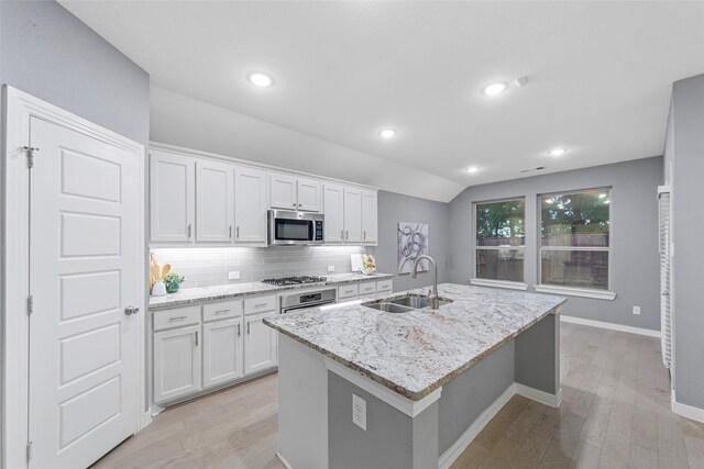 kitchen featuring a sink, light wood finished floors, appliances with stainless steel finishes, and white cabinets