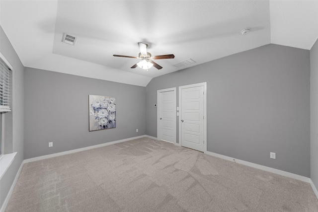 unfurnished bedroom with carpet floors, a ceiling fan, visible vents, and lofted ceiling