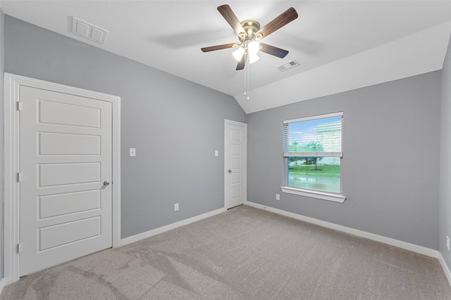 unfurnished bedroom with baseboards, carpet, vaulted ceiling, and visible vents