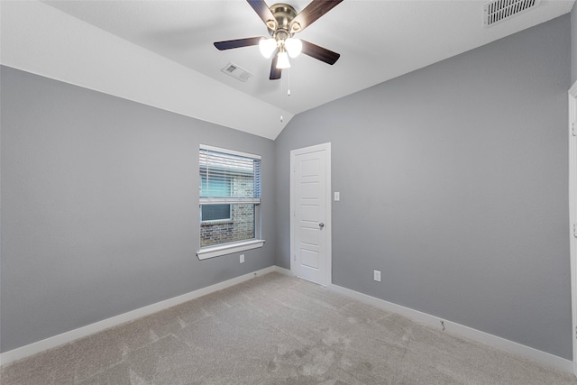 spare room with a ceiling fan, light colored carpet, visible vents, and baseboards