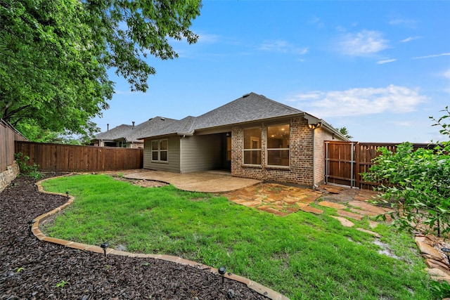 back of property featuring a fenced backyard, a yard, a patio area, and brick siding