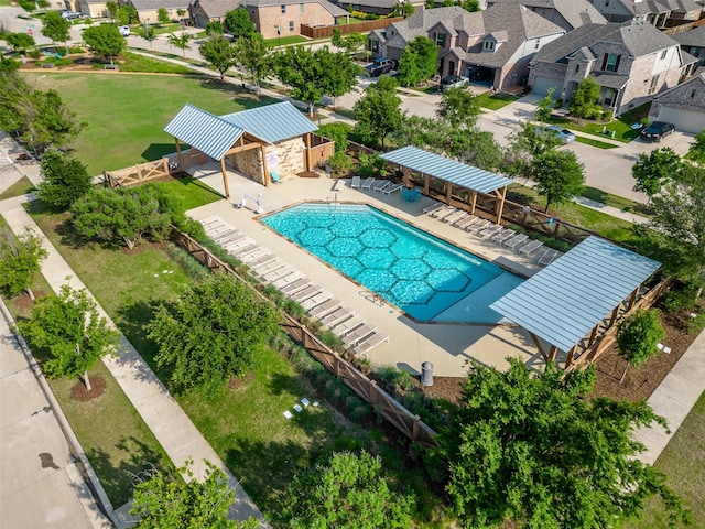 community pool with a residential view, fence, and a patio