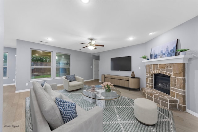 living area with ceiling fan, a fireplace, wood finished floors, baseboards, and recessed lighting