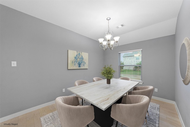 dining room featuring baseboards, a notable chandelier, visible vents, and light wood-type flooring