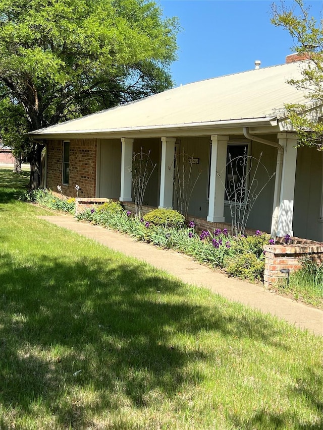 property entrance with a lawn and a chimney