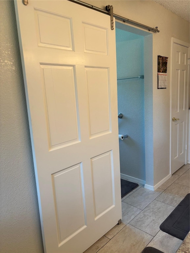 bathroom with baseboards and a textured wall
