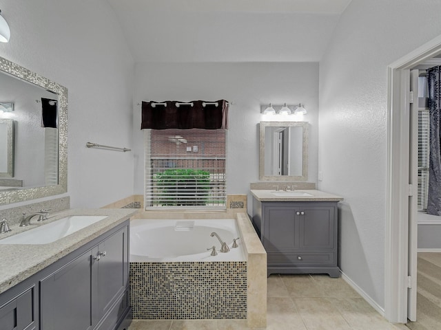 full bathroom with a sink, tile patterned flooring, a bath, and two vanities