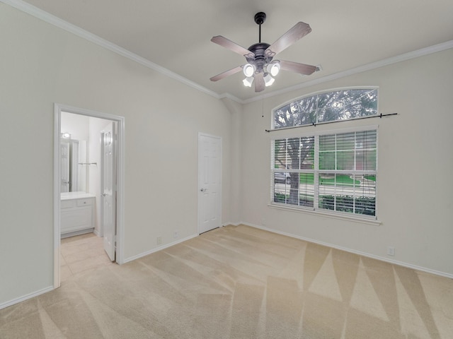 unfurnished bedroom with carpet flooring, crown molding, connected bathroom, a ceiling fan, and baseboards