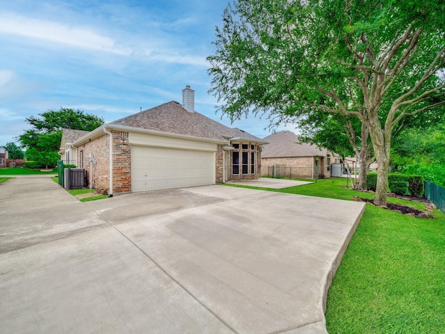 ranch-style home featuring brick siding, a garage, a front yard, a chimney, and concrete driveway