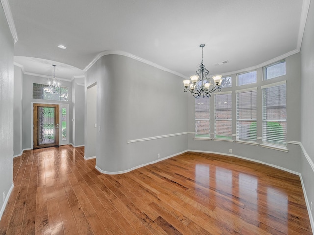 foyer featuring crown molding, baseboards, a notable chandelier, and wood finished floors