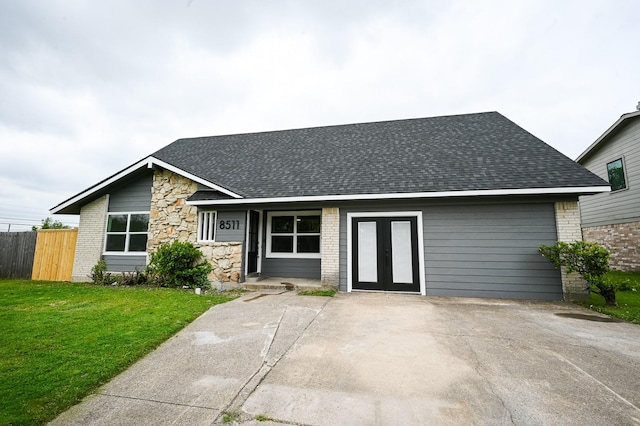 view of front facade featuring a front yard, fence, french doors, and roof with shingles