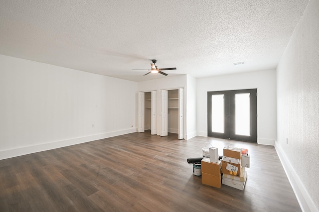 unfurnished living room featuring visible vents, wood finished floors, ceiling fan, a textured ceiling, and french doors