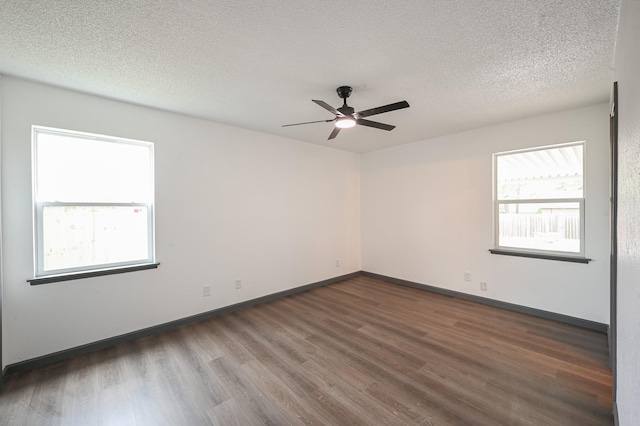 unfurnished room with a ceiling fan, baseboards, a healthy amount of sunlight, and wood finished floors