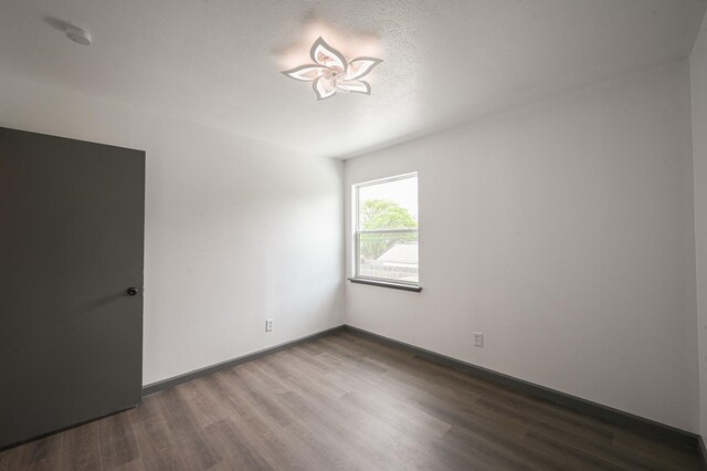 8511 Strathmore Dr, Dallas, TX 75238 - unfurnished room with wood finished floors and a textured ceiling