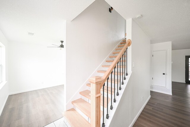 8511 Strathmore Dr, Dallas, TX 75238 - stairs featuring a textured ceiling, wood finished floors, ceiling fan, and baseboards