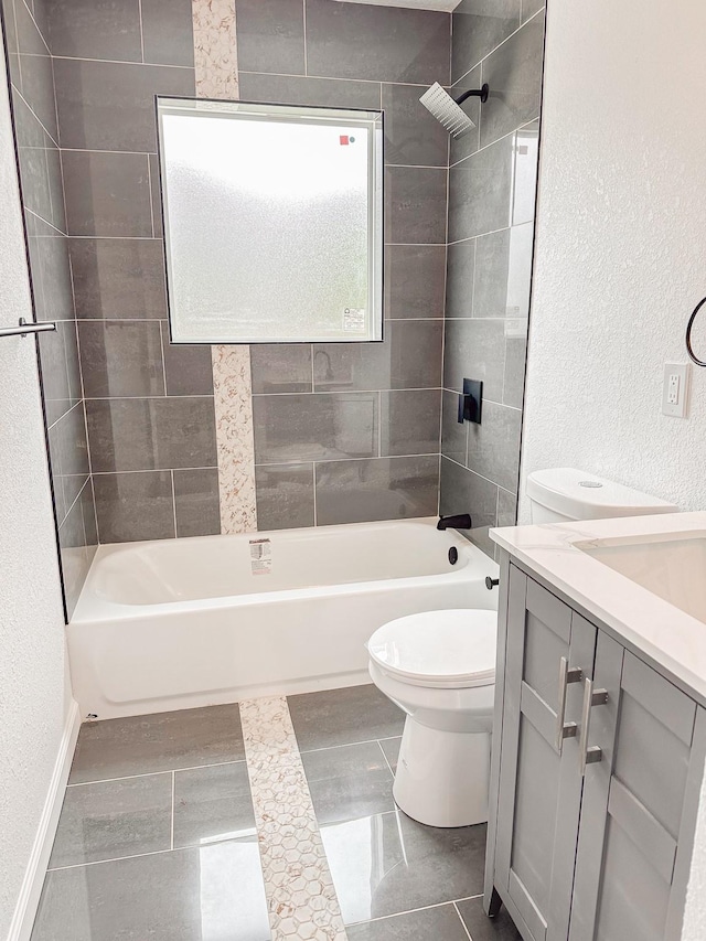 full bath featuring shower / bathtub combination, toilet, a textured wall, and vanity
