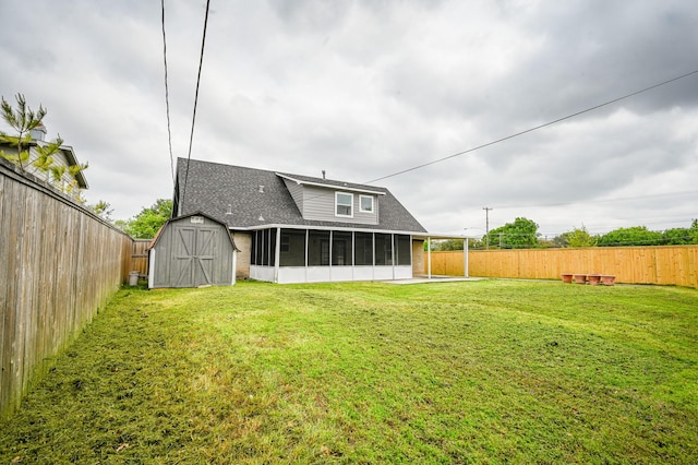 rear view of property featuring roof with shingles, a fenced backyard, a shed, and a sunroom