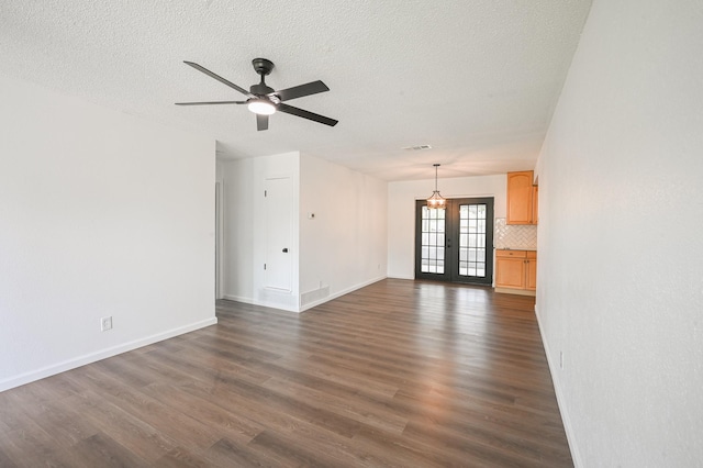 unfurnished living room featuring dark wood-type flooring, baseboards, and ceiling fan