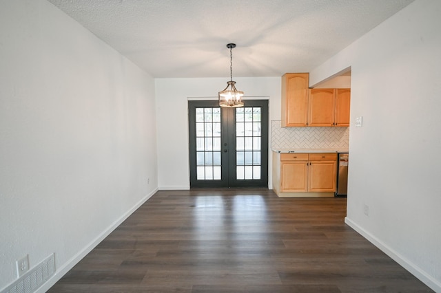 unfurnished dining area with visible vents, baseboards, a notable chandelier, and dark wood-style floors