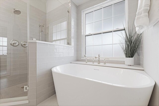 4460 Connemara Dr, Frisco, TX 75034 - bathroom featuring tile walls, a freestanding bath, and a stall shower