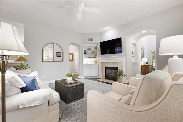 4460 Connemara Dr, Frisco, TX 75034 - living area featuring visible vents, a ceiling fan, built in features, baseboards, and arched walkways