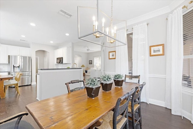 4460 Connemara Dr, Frisco, TX 75034 - dining room with arched walkways, dark wood finished floors, ceiling fan with notable chandelier, recessed lighting, and visible vents