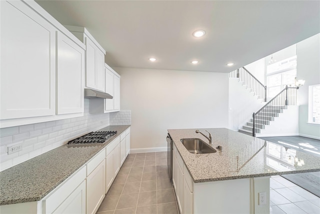 341 Gleneagles Dr, Garland, TX 75040 - kitchen featuring tasteful backsplash, a sink, baseboards, under cabinet range hood, and stainless steel appliances