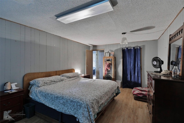 934 Burger St, Abilene, TX 79603 - bedroom featuring wood walls, a textured ceiling, and wood finished floors