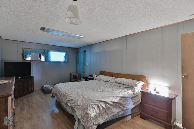 934 Burger St, Abilene, TX 79603 - bedroom with wooden walls, a textured ceiling, and wood finished floors