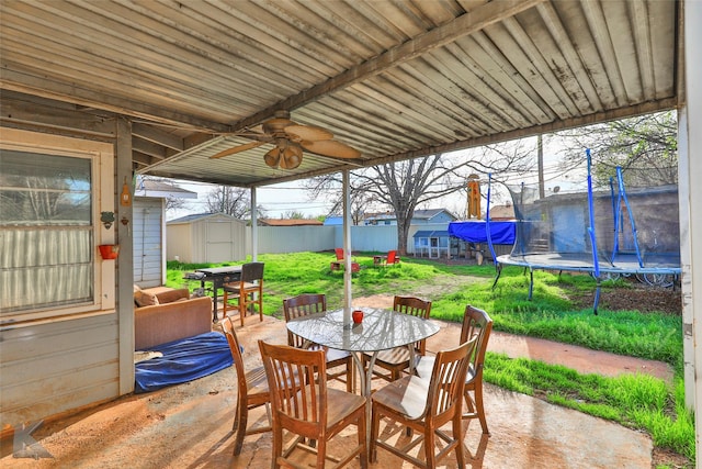 934 Burger St, Abilene, TX 79603 - view of patio / terrace with a storage unit, a trampoline, outdoor dining space, an outbuilding, and a ceiling fan