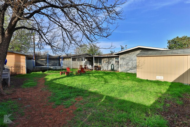 934 Burger St, Abilene, TX 79603 - view of yard featuring fence, a trampoline, an outdoor structure, and a shed