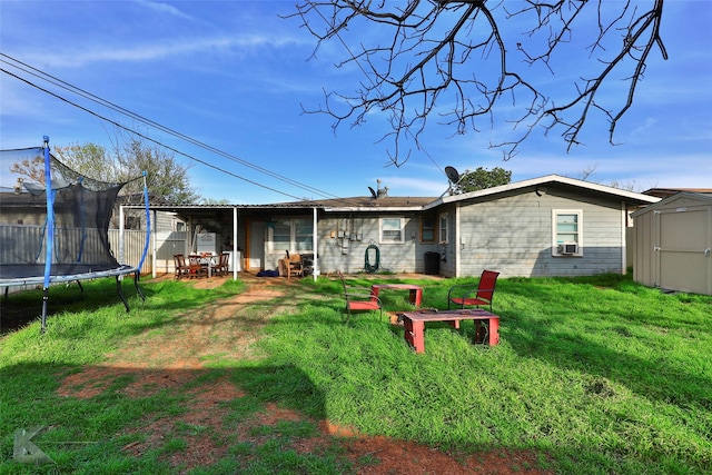 934 Burger St, Abilene, TX 79603 - back of house with a storage unit, a trampoline, cooling unit, a lawn, and an outdoor structure