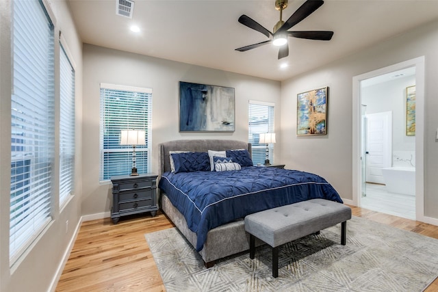 11955 Hoblitzelle Dr, Dallas, TX 75243 - bedroom featuring multiple windows, light wood-style flooring, baseboards, and connected bathroom