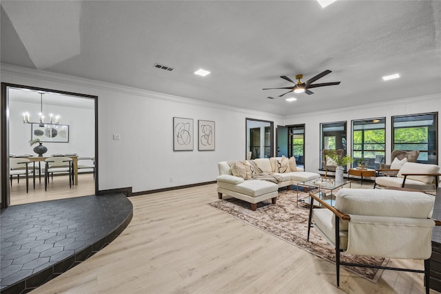 living area featuring crown molding, light wood-style floors, ceiling fan with notable chandelier, baseboards, and visible vents