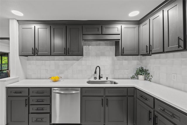 kitchen with stainless steel dishwasher, decorative backsplash, a sink, and light countertops